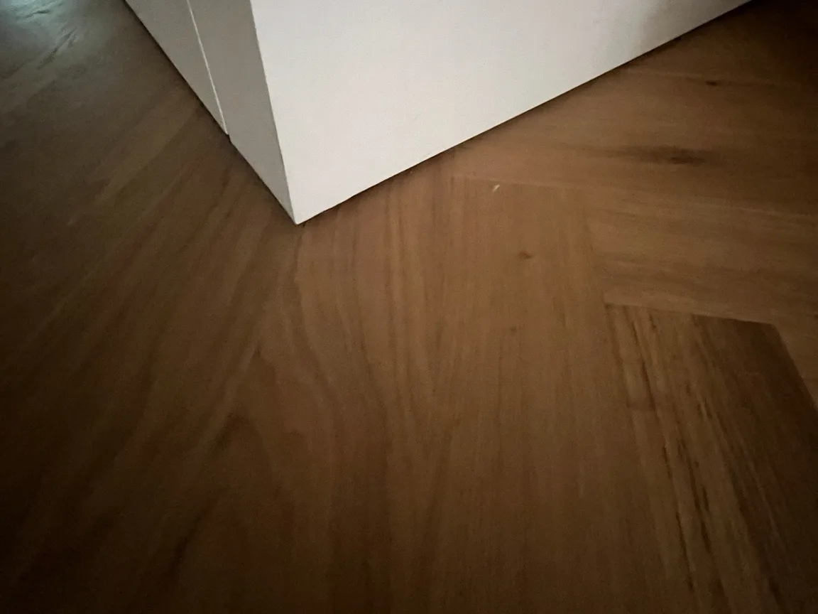 Detail van een visgraatvloer die strak op de wandafwerking aansluit, afwerkvloer door Clootcrans in Rotterdam