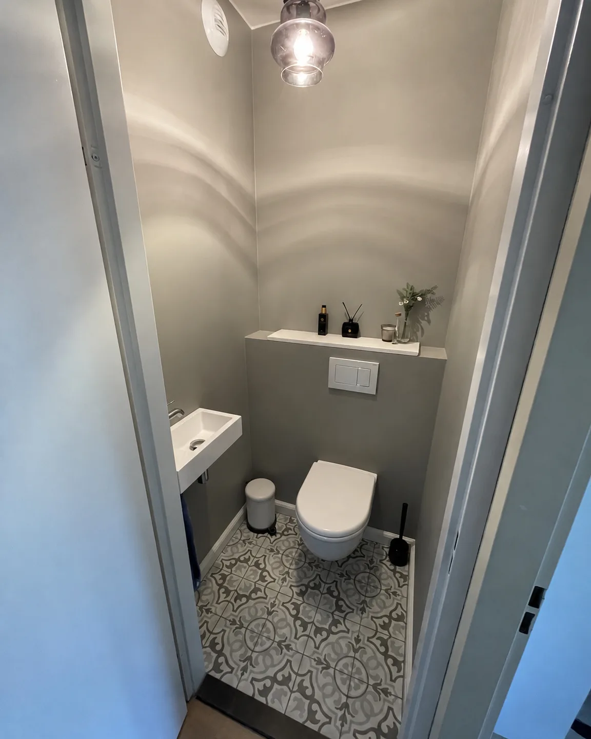 Toilet met patroonvloer en een zwevend closet na renovatie
