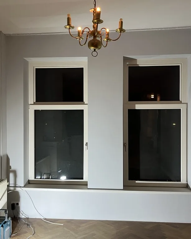 Kamer met nieuwe kozijnen, een gestucte wand en een visgraatvloer